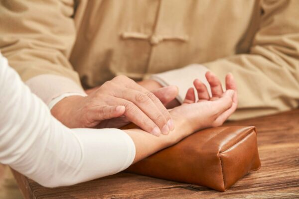 Checking pulse by touching veins on forearm